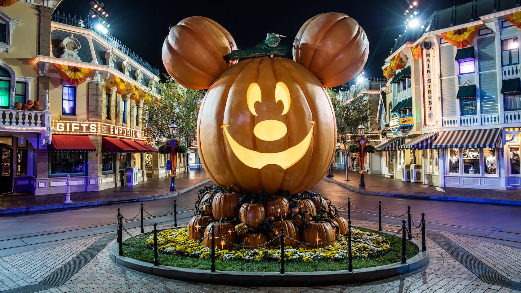 Halloween decorations and a giant jack-o-lantern on Main Street, Disneyland at night